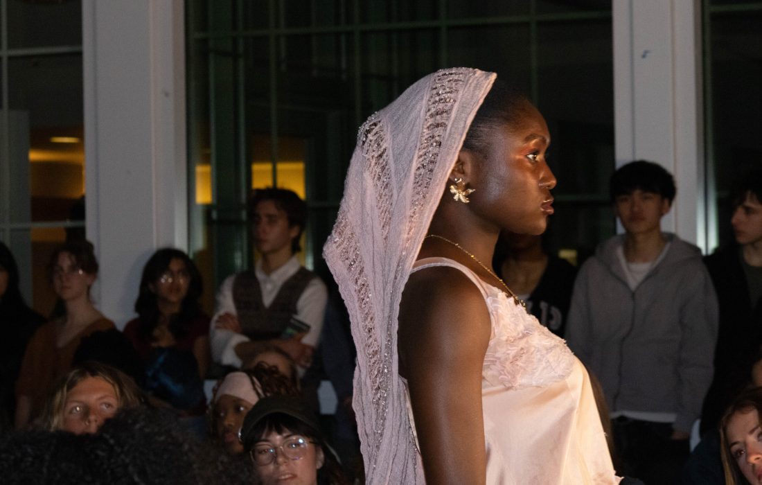 Model and student Oluwalagbara Kafaru struts down the runway in a wholly thrifted and borrowed outfit. (Skye Weaver | The Phoenix)