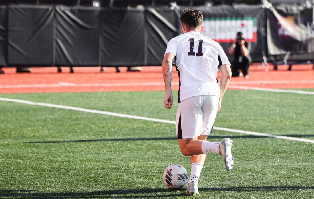 Third-year midfielder Jack McFeely runs upfield with the ball. (Kayla Tanada | The Phoenix)