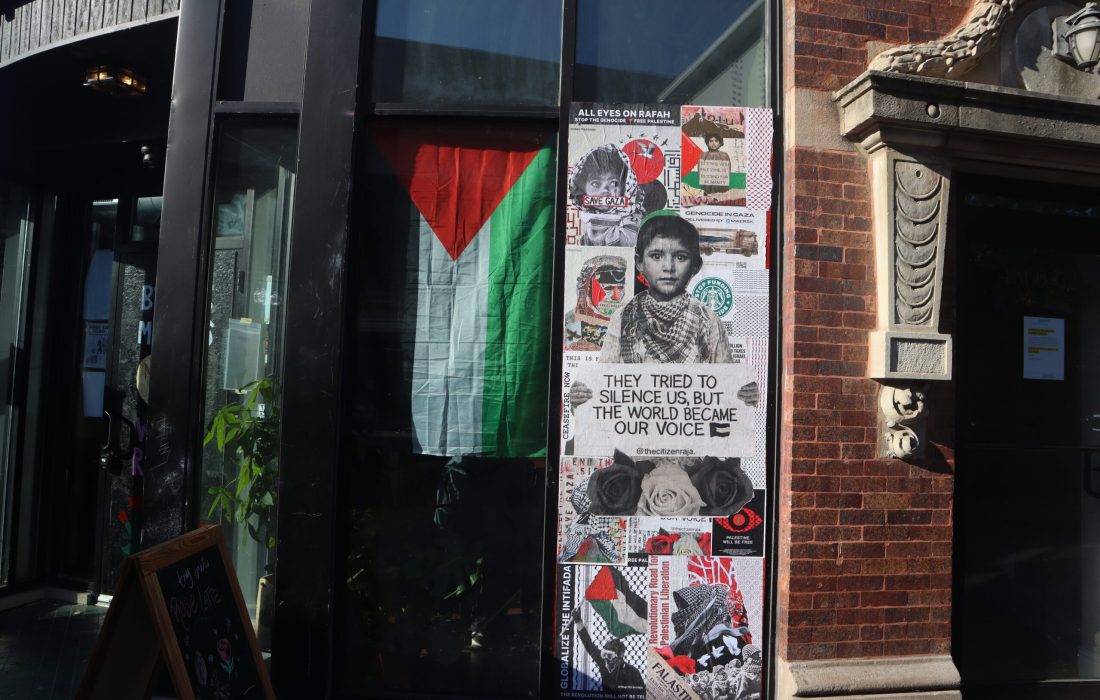 Palestinian flags and signs line the windows of Nabala Cafe. (Mao Reynolds | The Phoenix)