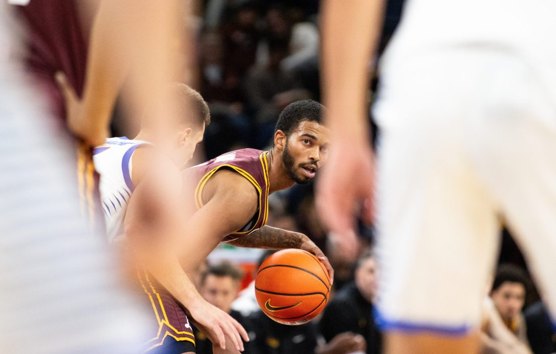 Redshirt third-year guard Justin Moore peers through DePaul defenders. (Megan Dunn | The Phoenix)