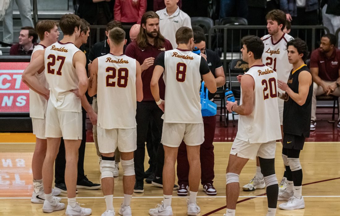 Men's volleyball huddles during a timeout. (Megan Dunn | The Phoenix)