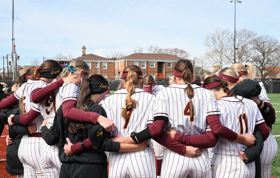 Softball huddles before a game against St. Bonaventure. (Melanie King | The Phoenix)