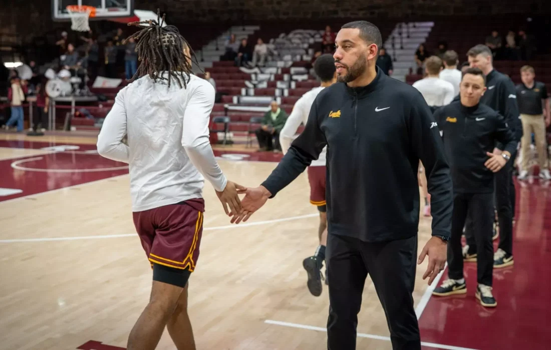 Dotson makes his way to the bench and greets Valentine after warmups. (Courtesy of Loyola Athletics)