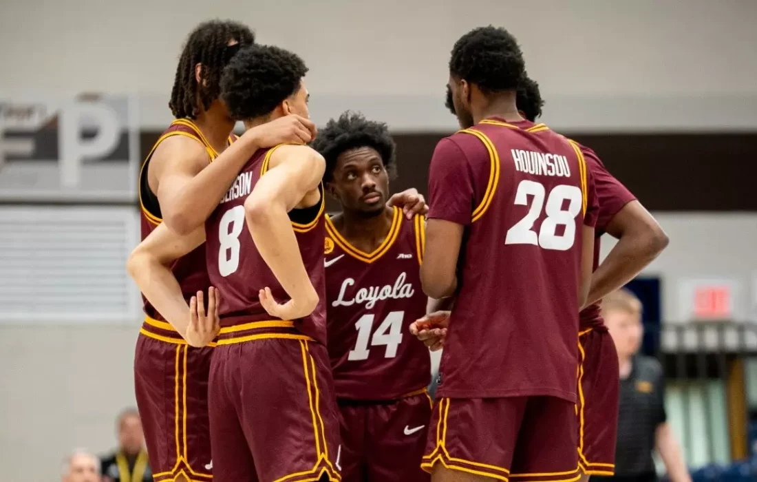 The Ramblers huddle during a pause in play. (Courtesy of Loyola Athletics)