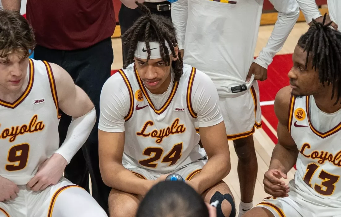 Alexander Richardson, Xavier Amos and Mile Rubin gather during a timeout. (Courtesy of Loyola Athletics)