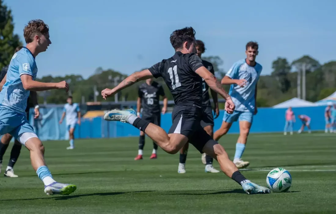 McFeely kicks the ball into Loyola's zone. (Courtesy of Rhode Island Athletics)