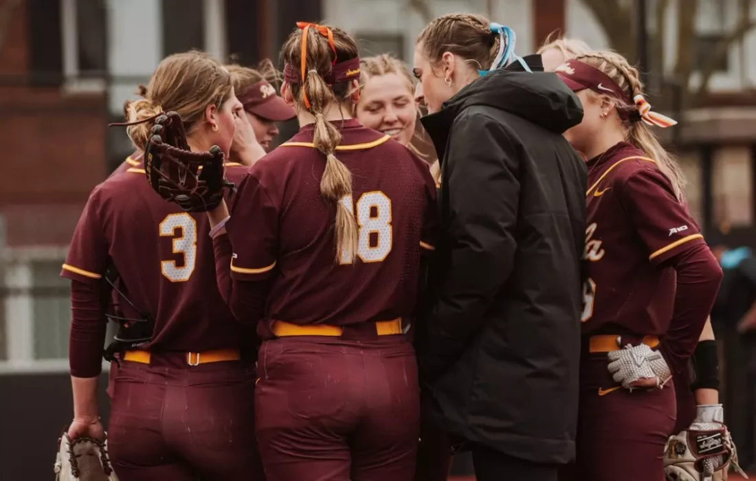 Loyola softball meets at the mound during their 9-8 loss to Miami University Ohio. (Courtesy of Loyola Athletics)